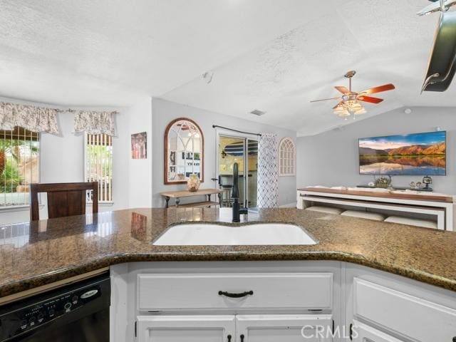 kitchen with a ceiling fan, a sink, a textured ceiling, black dishwasher, and white cabinetry