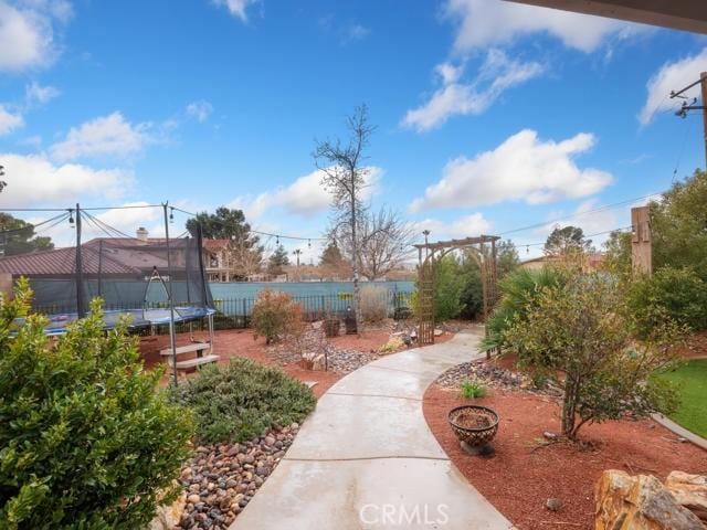 surrounding community featuring a trampoline and fence