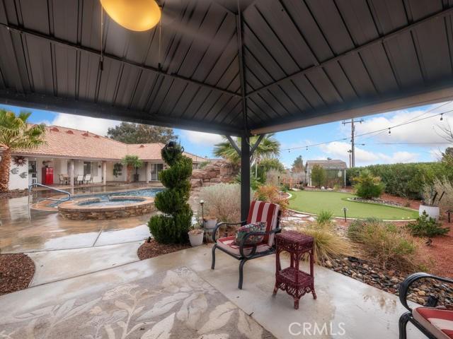 view of patio featuring a gazebo and an in ground hot tub