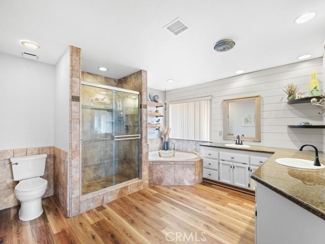 full bathroom featuring wood finished floors, visible vents, a sink, a shower stall, and a bath