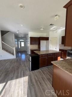 kitchen with dark brown cabinets, wood finished floors, and a kitchen island