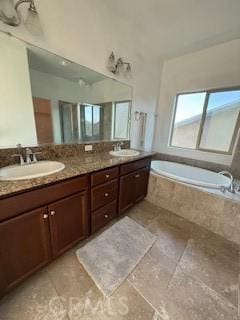 bathroom with a sink, a garden tub, and double vanity