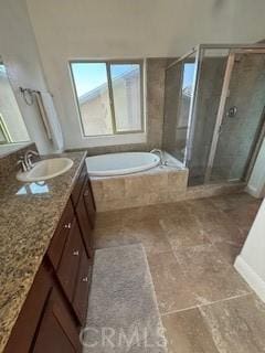 bathroom featuring vanity, a garden tub, a shower stall, and stone finish flooring