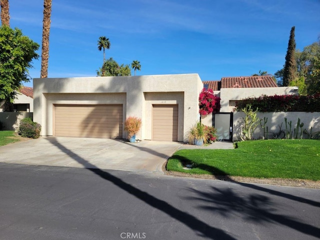 view of front of property with a front yard, an attached garage, driveway, and stucco siding