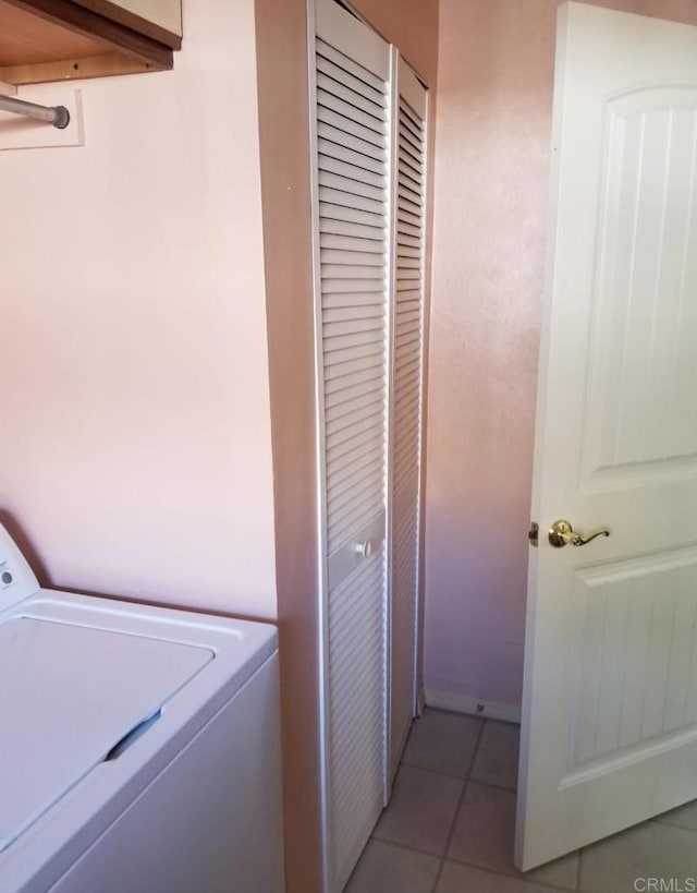 washroom featuring washer / clothes dryer, laundry area, and light tile patterned flooring