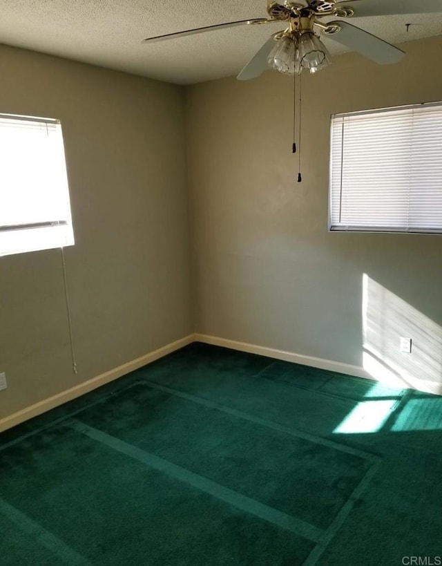 spare room with plenty of natural light, carpet, baseboards, and ceiling fan