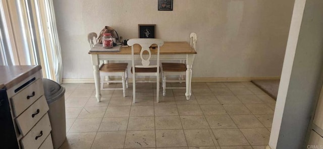 dining area featuring light tile patterned floors and baseboards