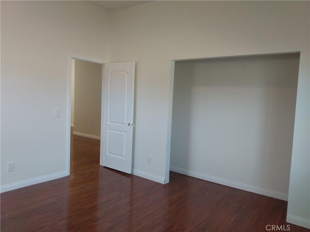 unfurnished bedroom with wood finished floors and baseboards