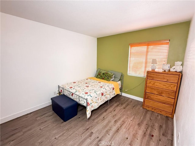 bedroom with baseboards and wood finished floors