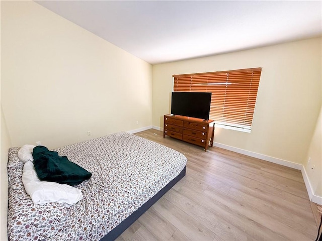 bedroom with baseboards and light wood-type flooring