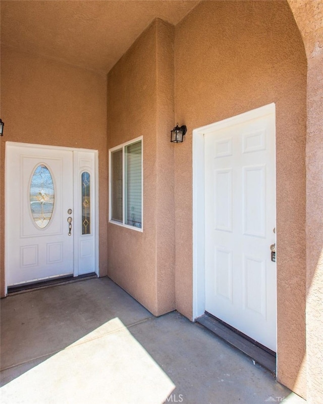 entrance to property featuring stucco siding