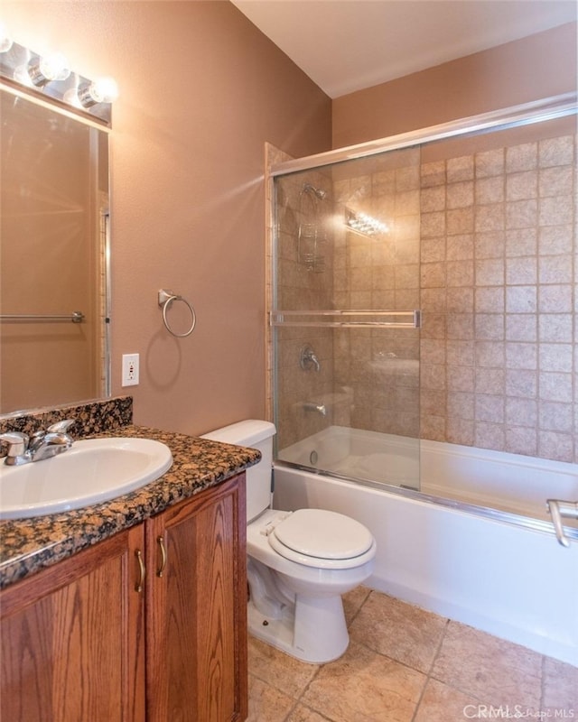 bathroom featuring combined bath / shower with glass door, toilet, vanity, and tile patterned floors