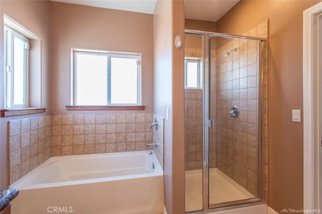 full bath featuring a garden tub and a shower stall