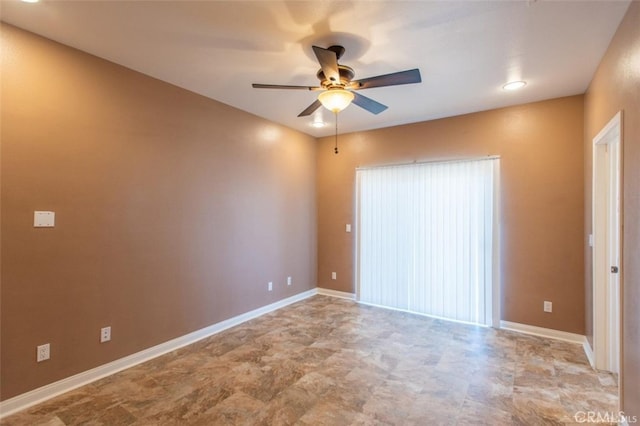 spare room with baseboards and ceiling fan