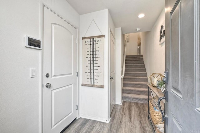 foyer with stairs, recessed lighting, baseboards, and wood finished floors