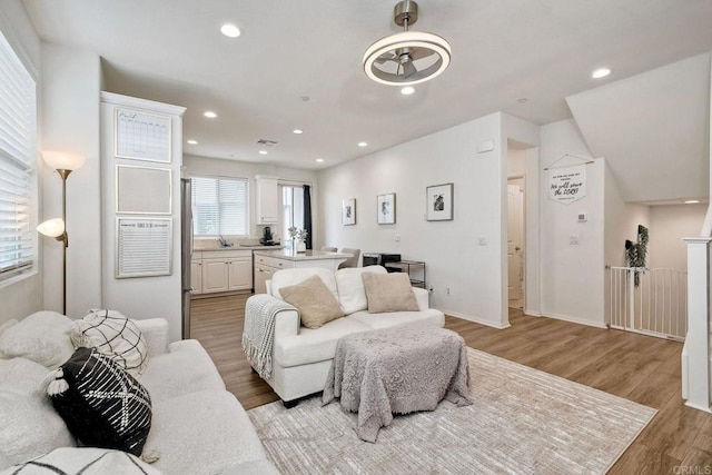 living room featuring recessed lighting, visible vents, and light wood-style flooring
