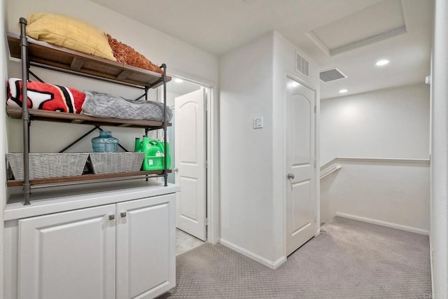 interior space with baseboards, attic access, and light colored carpet