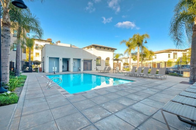 pool with a patio and fence