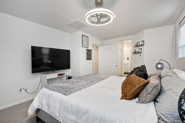 carpeted bedroom with connected bathroom, baseboards, and visible vents