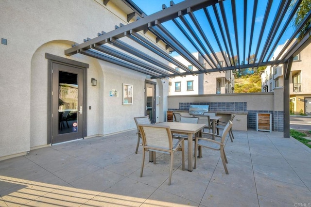 view of patio / terrace with exterior kitchen, outdoor dining space, and a grill