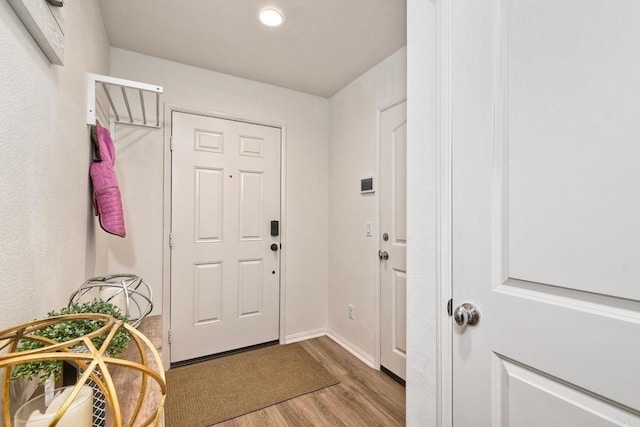 interior space featuring baseboards, recessed lighting, and wood finished floors