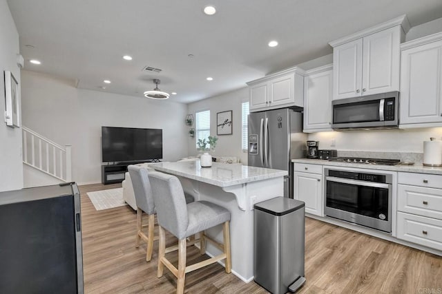 kitchen featuring appliances with stainless steel finishes, light wood-type flooring, recessed lighting, and white cabinetry