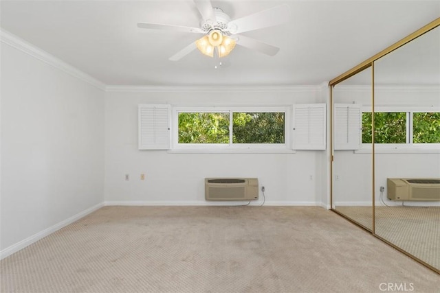 carpeted spare room with plenty of natural light, an AC wall unit, and ornamental molding