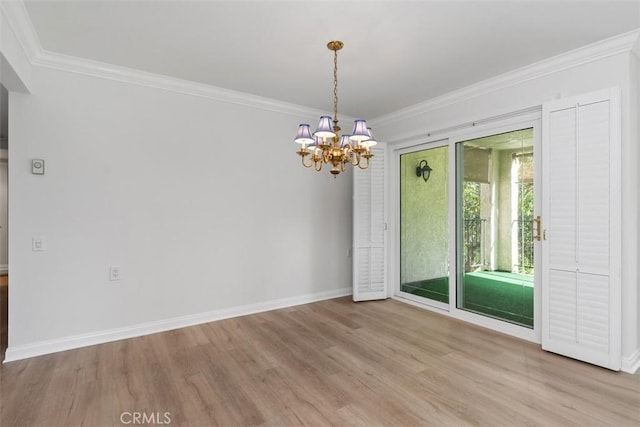 unfurnished room with an inviting chandelier, baseboards, light wood-type flooring, and ornamental molding