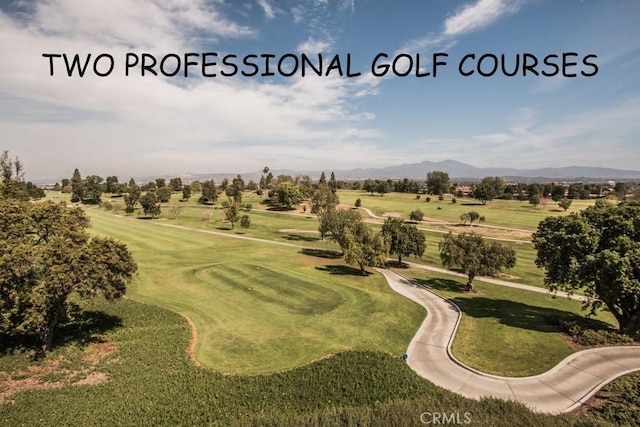 view of property's community featuring a mountain view, golf course view, and a yard