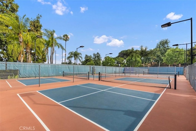view of tennis court featuring fence and community basketball court