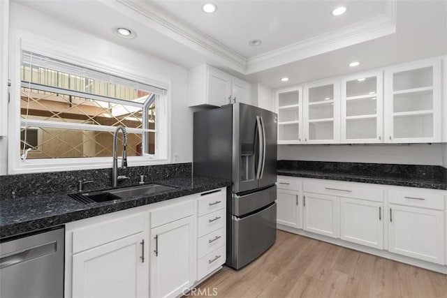 kitchen featuring a sink, glass insert cabinets, ornamental molding, white cabinets, and appliances with stainless steel finishes