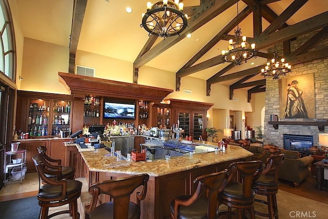 bar with beamed ceiling, a notable chandelier, high vaulted ceiling, and indoor bar