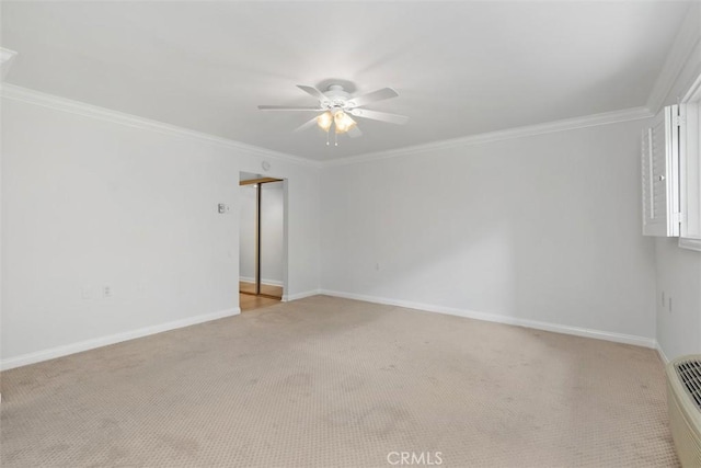 empty room featuring crown molding, light colored carpet, baseboards, and ceiling fan