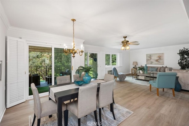 dining space with ceiling fan with notable chandelier, crown molding, light wood-style flooring, and baseboards