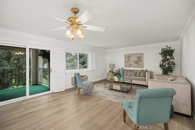 living room with wood finished floors, crown molding, a ceiling fan, and baseboards