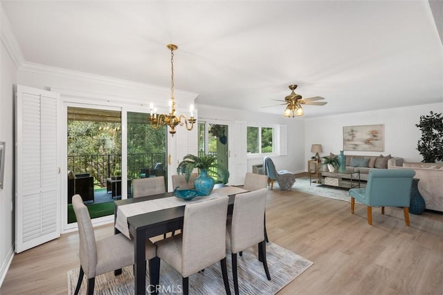 dining area featuring baseboards, ceiling fan with notable chandelier, light wood-style floors, and crown molding