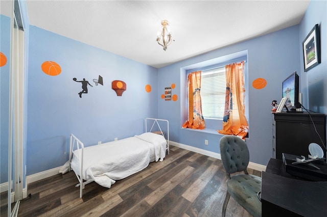 bedroom featuring a chandelier, baseboards, and wood finished floors