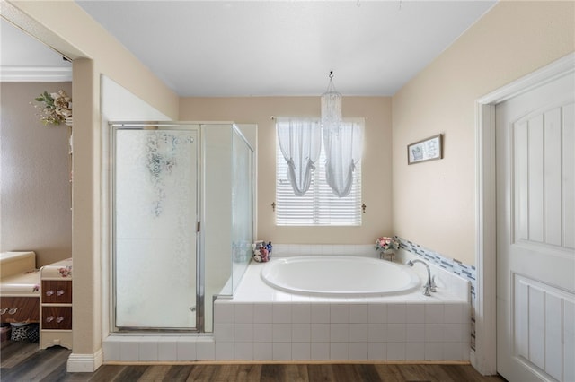 full bathroom featuring a bath, a shower stall, and wood finished floors