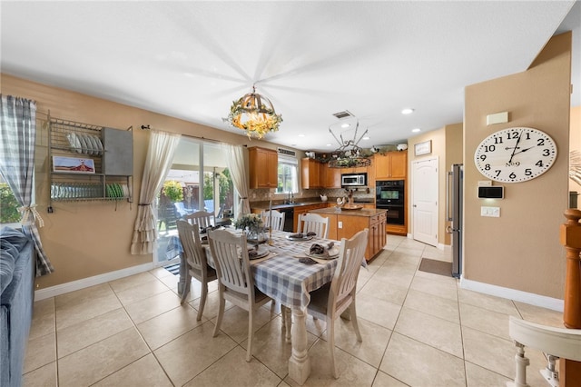 dining room featuring light tile patterned flooring, baseboards, visible vents, and a chandelier