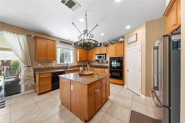 kitchen with visible vents, black appliances, a sink, tasteful backsplash, and light tile patterned flooring