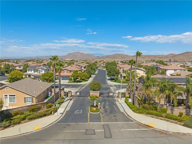 view of road featuring a gated entry, a residential view, a gate, and sidewalks