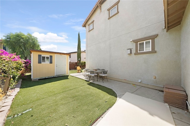 view of yard featuring a patio area, a storage shed, an outdoor structure, and fence