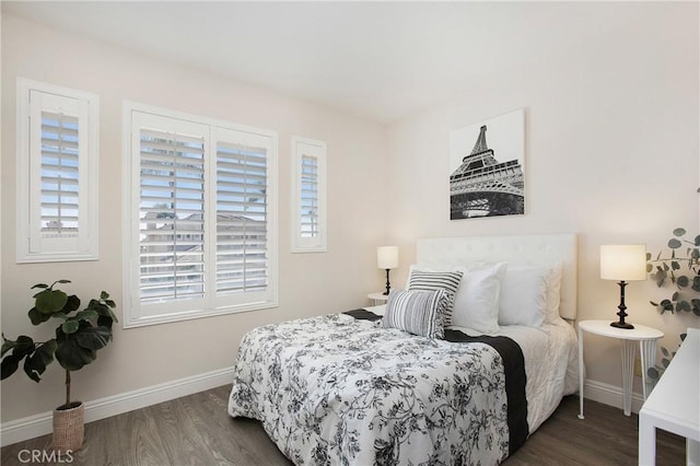 bedroom with dark wood-type flooring, multiple windows, and baseboards
