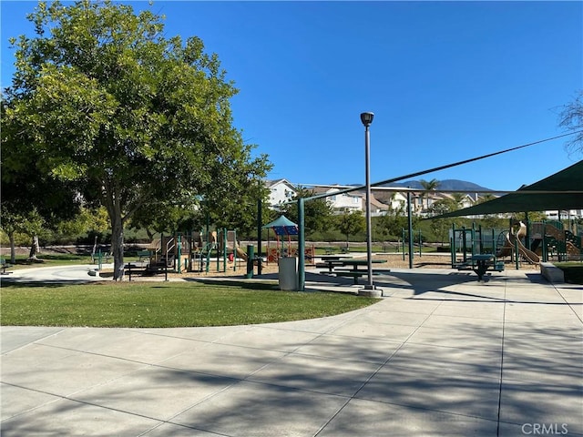 view of home's community featuring playground community and a yard