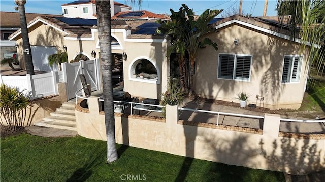 view of front of property featuring a gate, stucco siding, fence private yard, and a tile roof