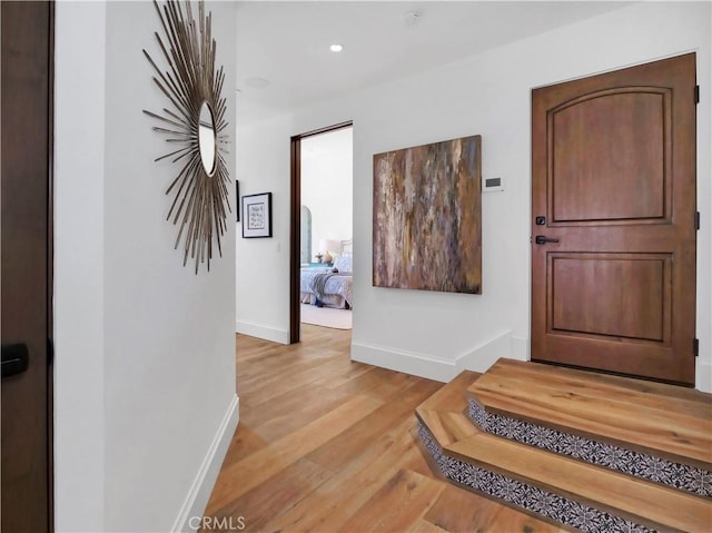 foyer with recessed lighting, baseboards, and light wood-type flooring