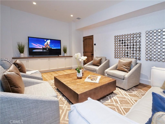 living room with light wood finished floors, visible vents, recessed lighting, and baseboards