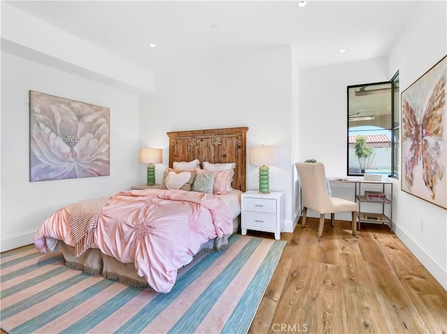 bedroom with recessed lighting, wood finished floors, and baseboards