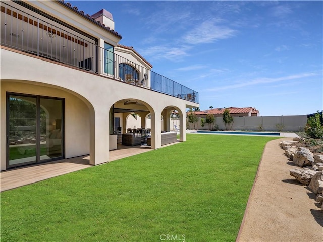 view of yard with a patio, a balcony, a fenced in pool, fence, and an outdoor hangout area