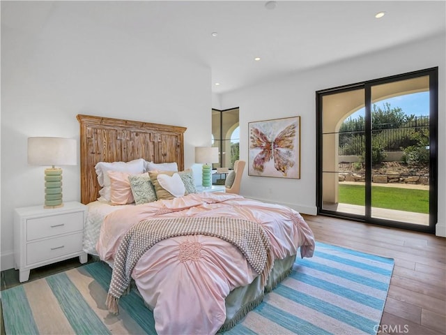 bedroom with access to outside, recessed lighting, wood finished floors, and baseboards